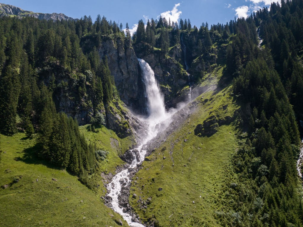 the staubifall waterfall, a powerful waterfall cascading down from a cliff on a bright sunny day.