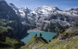 The Oeschinensee hike view from the trail over the turquoise waters of the lake and the surrounding cliffs