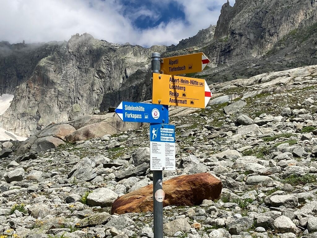 Mountain signpost pointing in different directions showing different difficulty levels