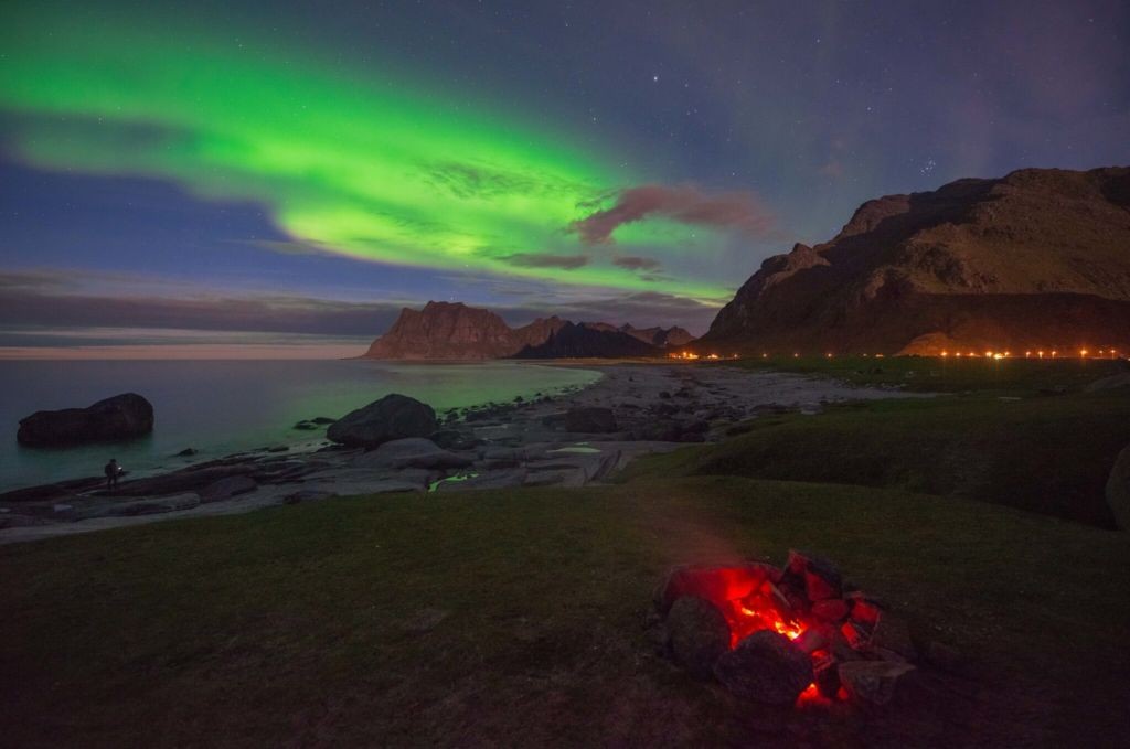 Northern Lights above a campfire on a beach