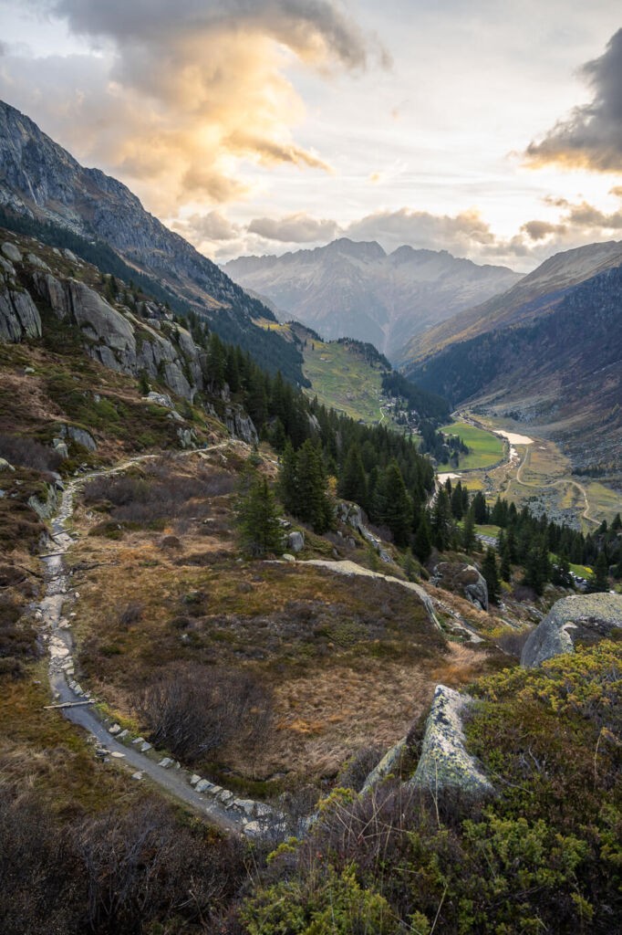 Sunrise on a trail in the Swiss alp and view over the valley underneath