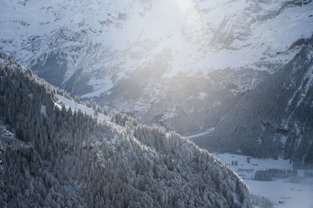 Light warming a dark alpine valley in the swiss alps around engelberg