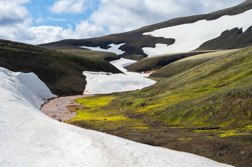 Trail along the Rauðufossakvísl river partially covered in snow