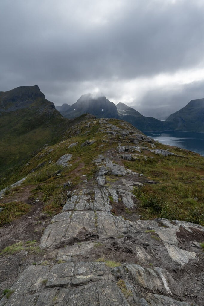 View of the trail to Segla on a cloudy day with fjords and mountains in the background