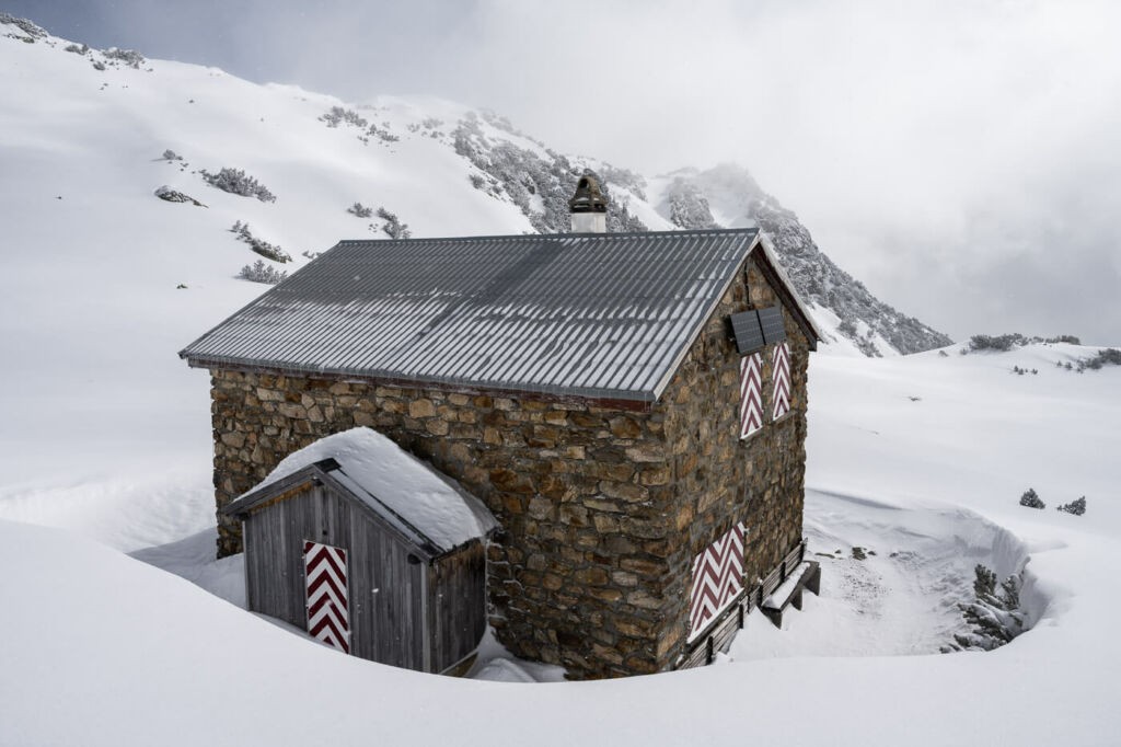 Sunniggrathutte, a hut surrounded by snow in the Swiss alps