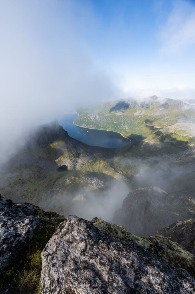 View from the top of Grytetippen, fjords and mountains surrounded by clouds.