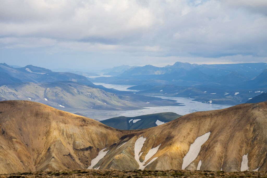 light on the colourful Landmannalaugar mountains with a river in the background.