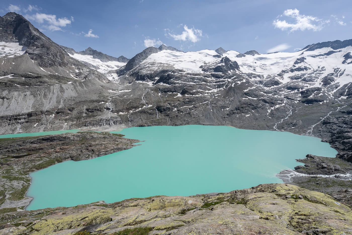 Gaulisee a deep turquoise alpine lake surrounded by mountains with glaciers on a hike from Mattenalpsee