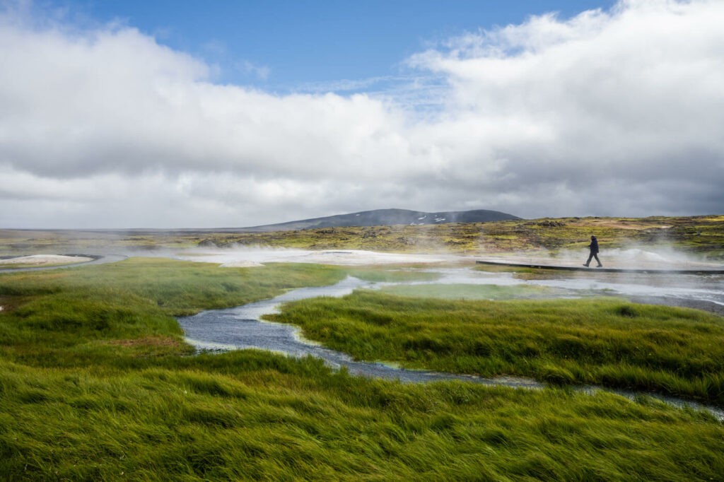 geothermal river in Hveravellir with a hiker passing by