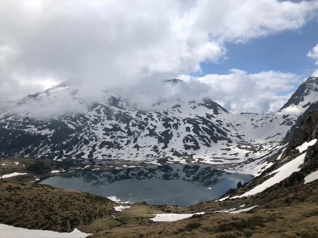 Murgsee, an alpine lake in spring surrounded by melting snow