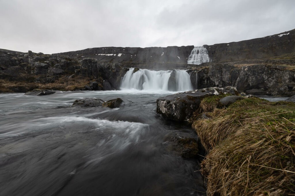 Two waterfalls dropping off a cliffs in the westfjords of Iceland