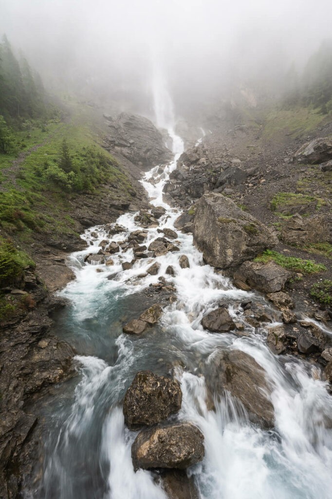 Lower Engstligen Fall and its raging waters on a day with fog during a hike
