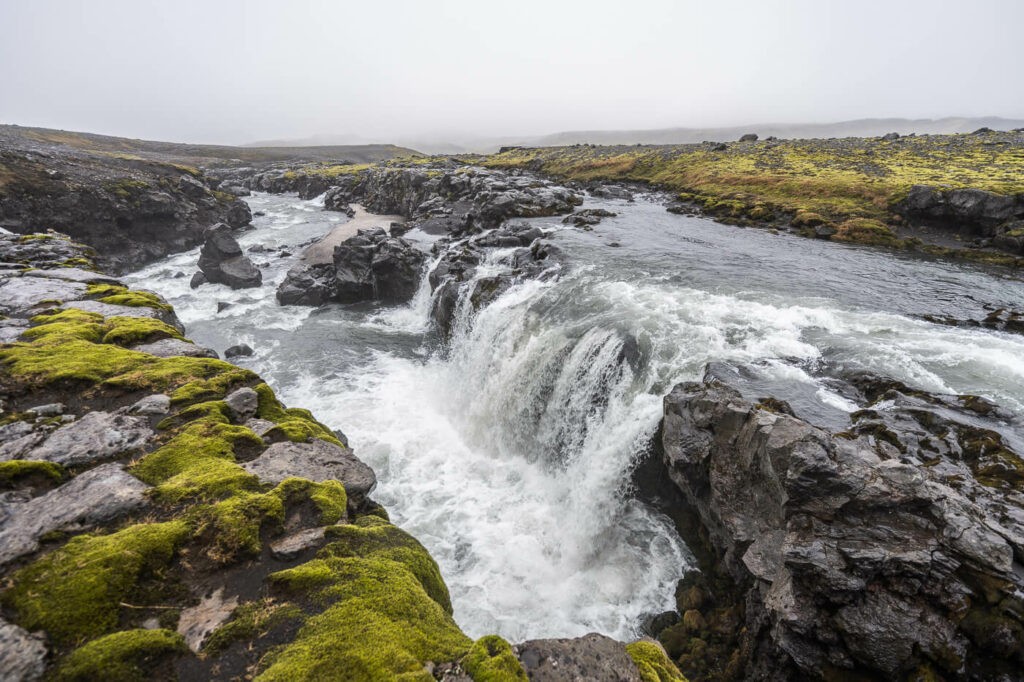 A small waterfall on the skoga river in a foggy landscape in Iceland on the skogafoss waterfall way hike