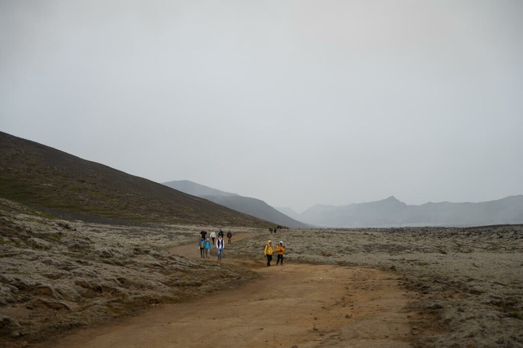Hikers hiking to the 2023 fagradalsfjall eruption in a barren landscape 