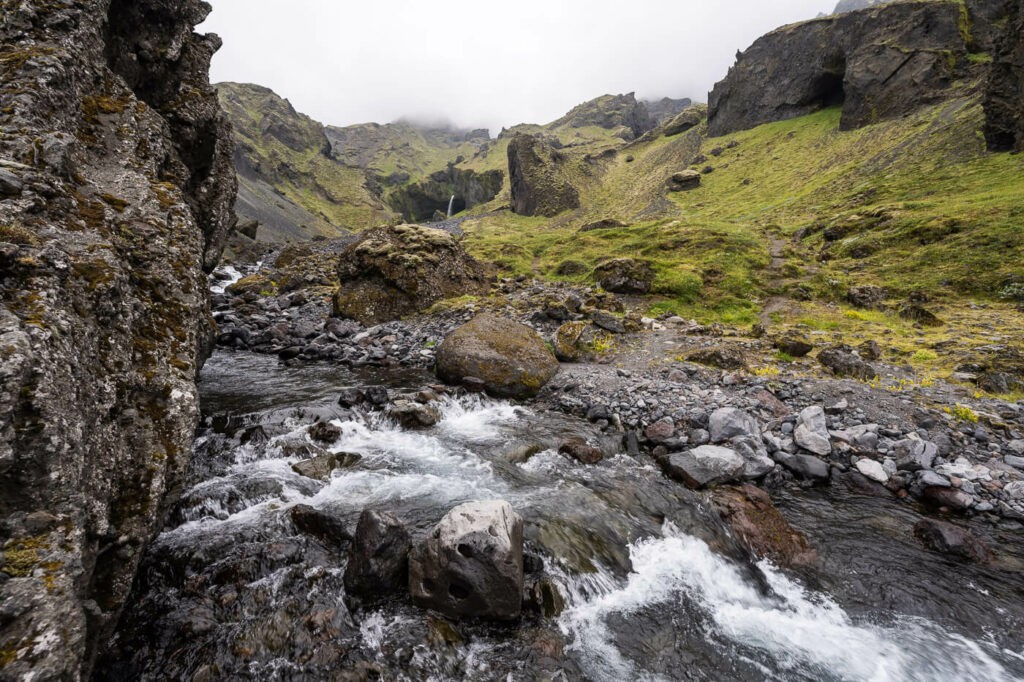 Water stream in Iceland with a waterfall in the background