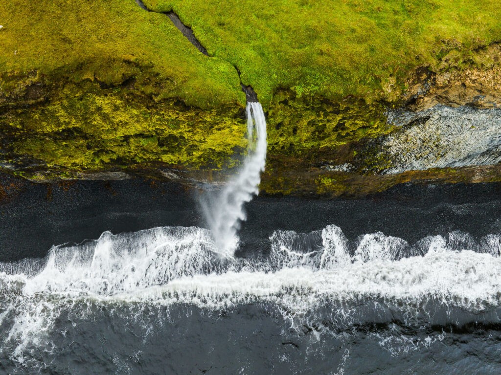 aerial photo of a waterfall in Iceland falling direction into the sea