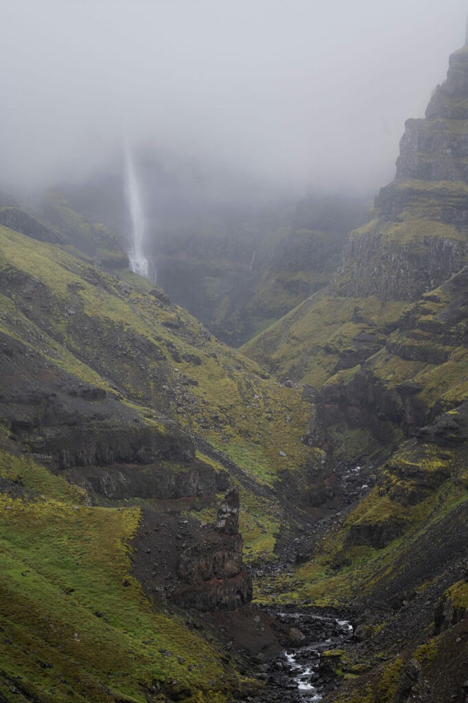 Strutsfoss and the Strutsgil canyon in the cloud and green lush vegetation