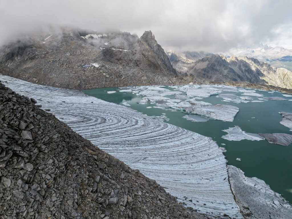 Chüebodengletscher and its Swiss Iceberg Lake under the clouds