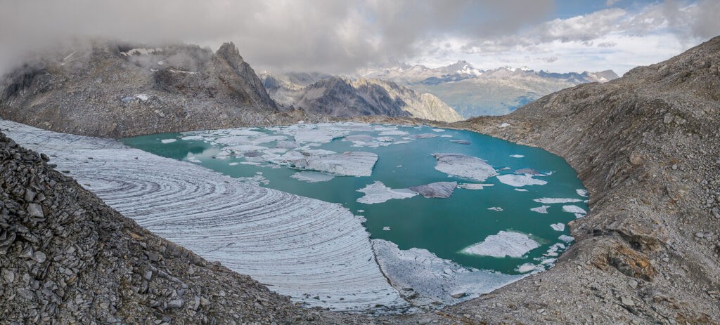 Panoramic image of Chüebodengletscher and its icebergs floating into the lakes in Switzerland