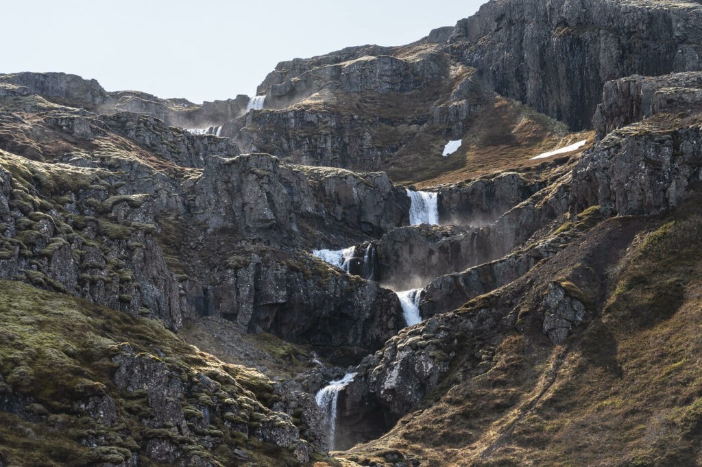 The multiple waterfall layers of Klifubrekkarfossar waterfalls in Iceland visited during a camper van road trip in Iceland.