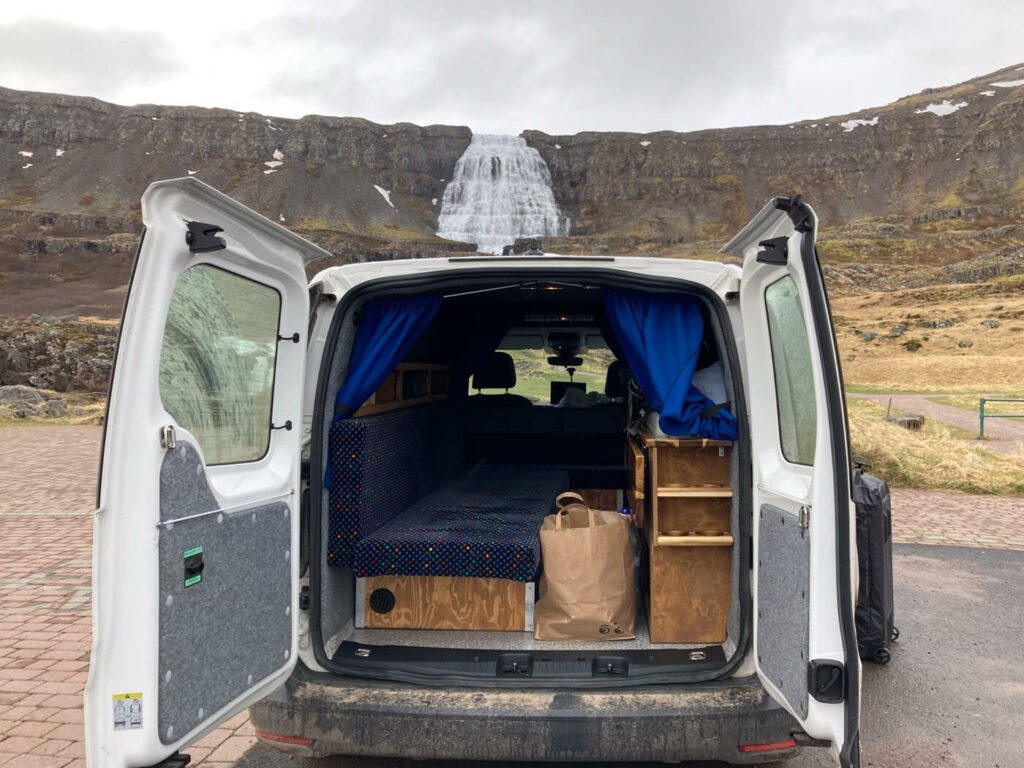 View of a campervan in front of the Dynjandi waterfall during an Iceland Campervan Roadtrip.