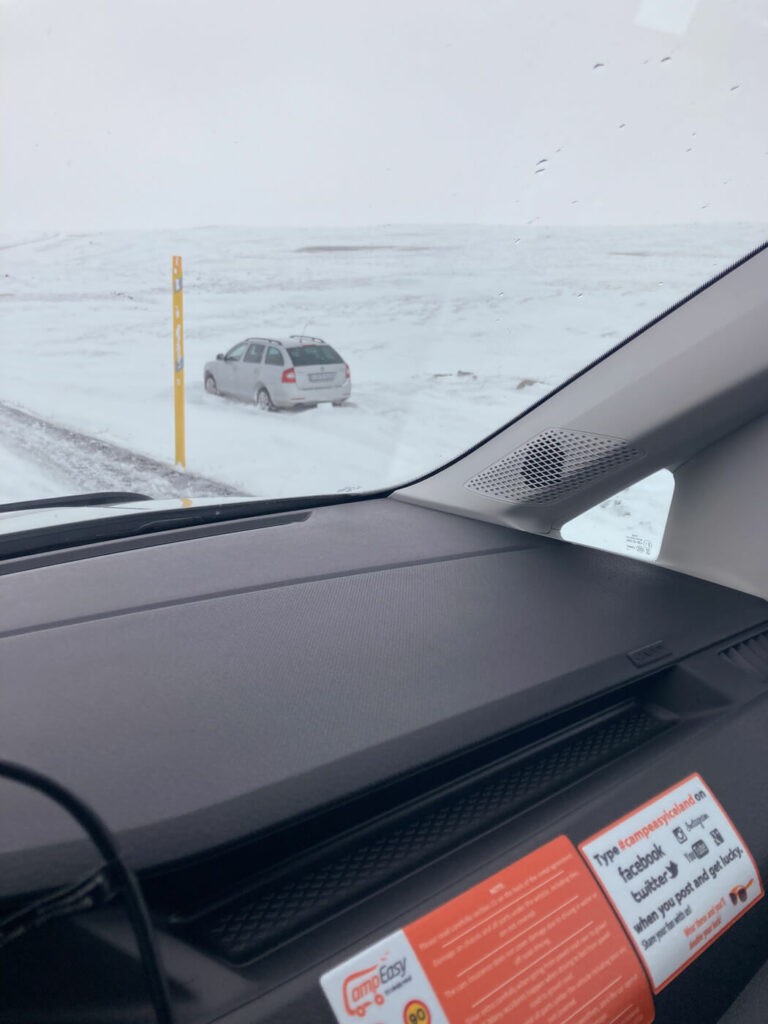 Car off the road in a snow field in Iceland during a snow storm.