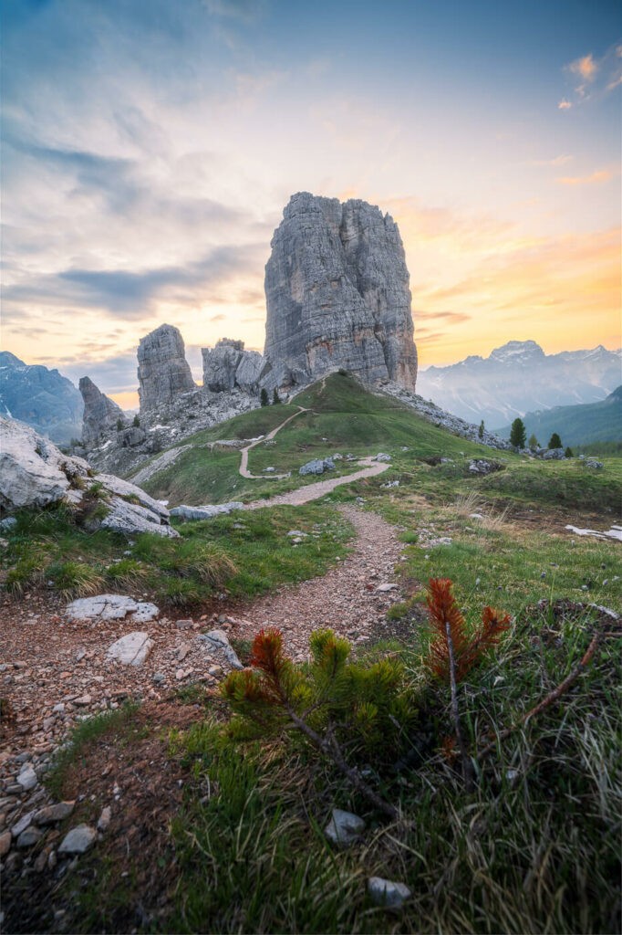 Vertical image of Le Cinque Torri and a hiking path shortly before sunrise
