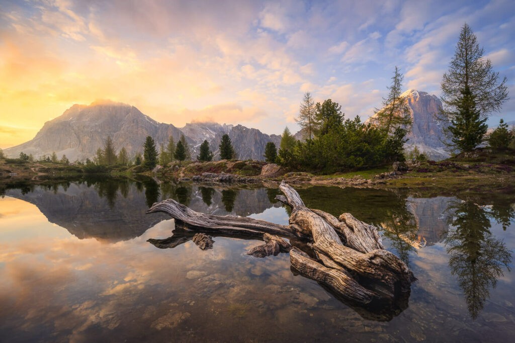 Sunset at Lago di Limides in the dolomites, with a log in the foreground.