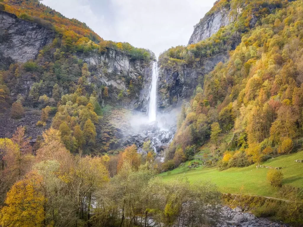 Drone photos of the Foroglio waterfall surrounded by woods showing the colorful autumn leaves