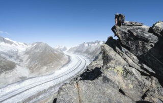 Hiker looking at the Aletsch glacier from the UNESCO High Altitude ridge trail