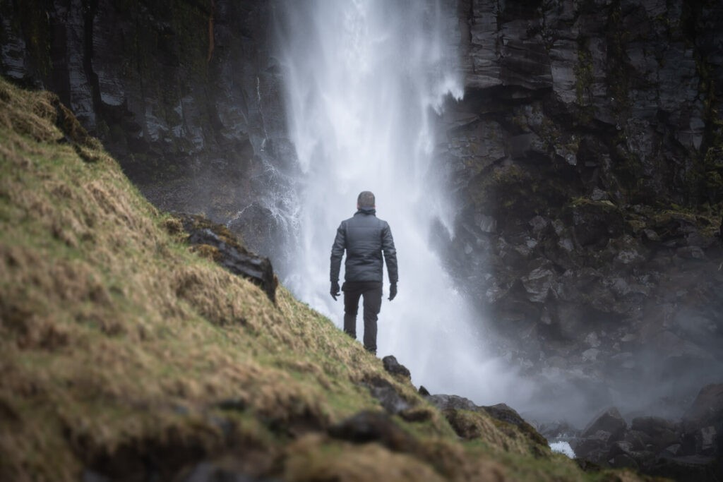 man watching a waterfall in iceland
