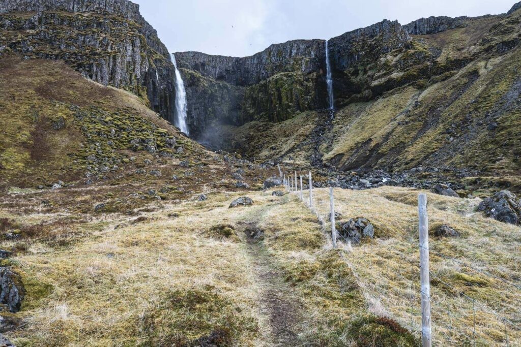 Hiking trail leading to the waterfall Grundarfoss which can be seen in the background.