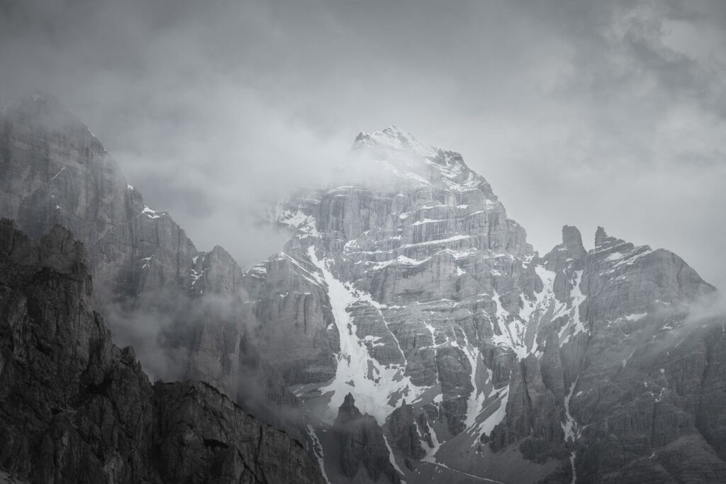 mountain peaks in the clouds in the dolomites in a moody an atmospheric image