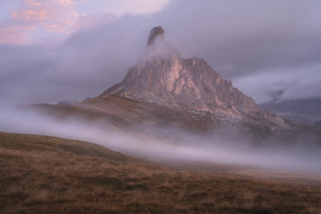 Sunrise Hike to Passo Giau with fog claring the landscape as the sun rise