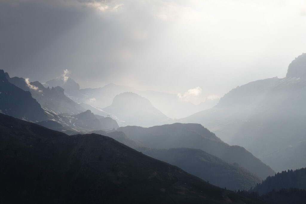multiple layers of mountains under a heavenly light