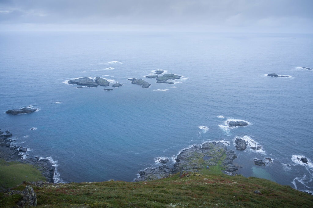 View of some rocks off the coast from the top of Mulstøtinden on the Røren hiking trail on a cloudy days