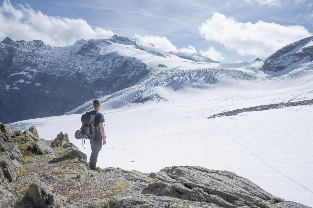 Hiker watching the glacial landscape high up on the swiss alps.