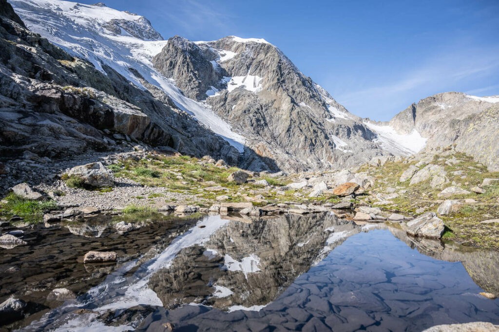 mountain reflecting in a small fresh water pond in the swiss alps above the sustenpass