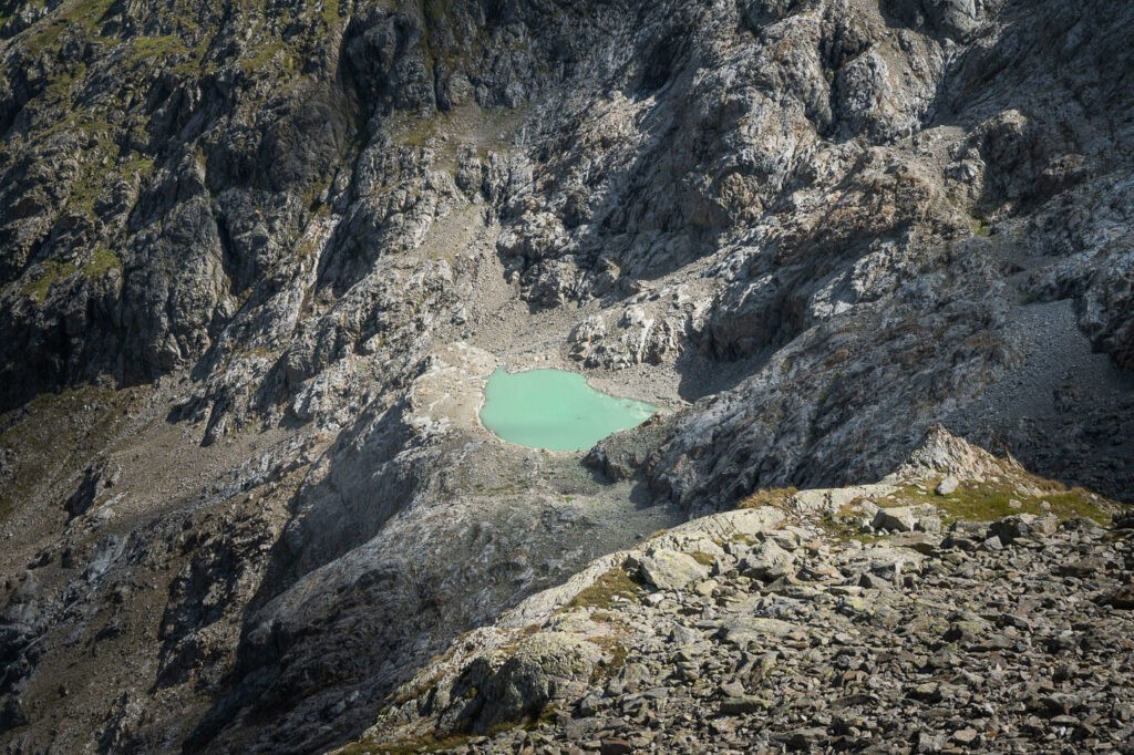 small alpine lake lit by the light of the sun