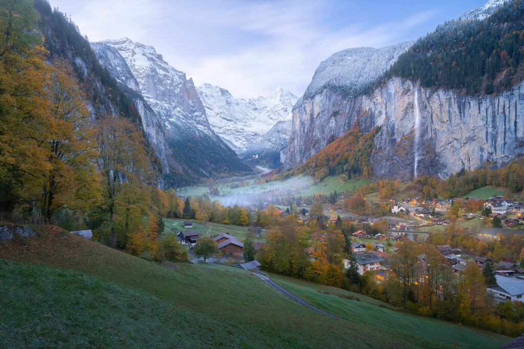 view of Lauterbrunnen and Staibbachfall from one of the best viewpoints from the hiking trail to Wengen, a beautiful valley with a waterfall and a village.
